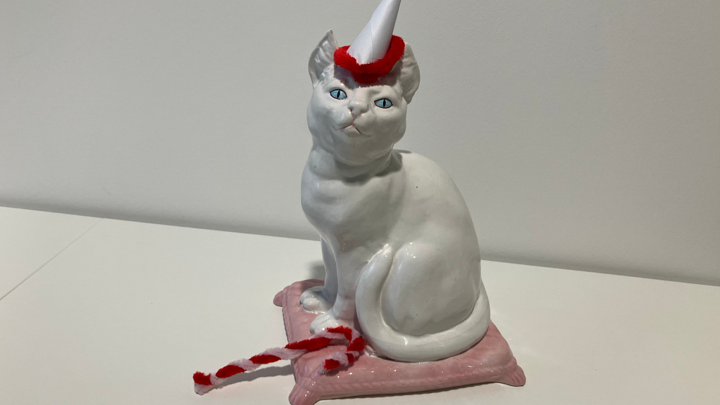 Decorative Christmas cat with hat andcandy cane.